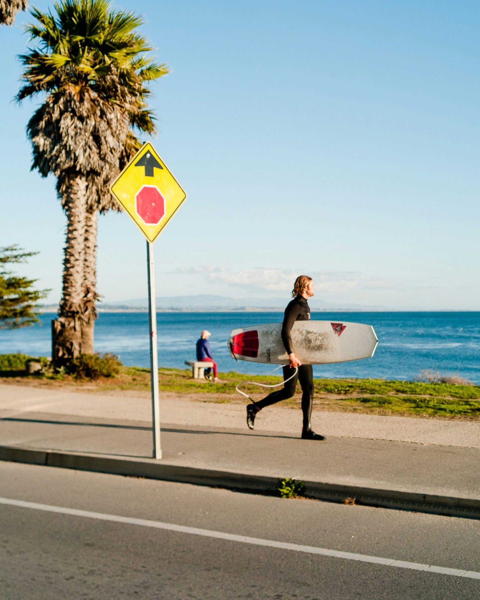 man holding surfboard near beach